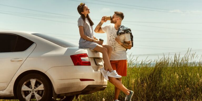 young couple with rental car